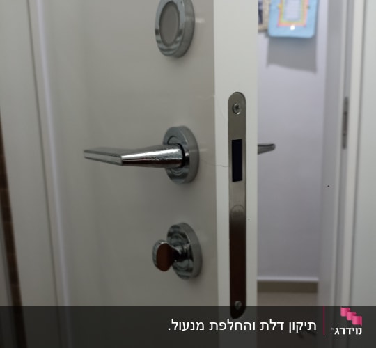 דלת פתוחה עם מנעול וידית מתכת כסופה